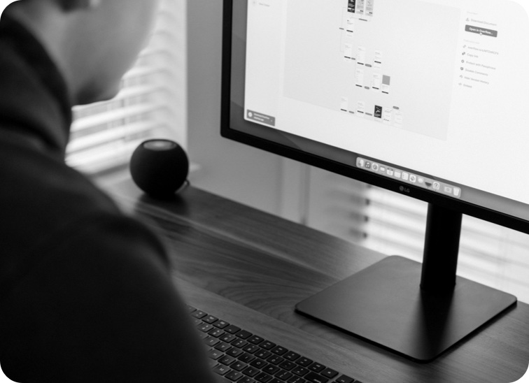 Side view of Justin working on an a user flow diagram in Overflow on his computer